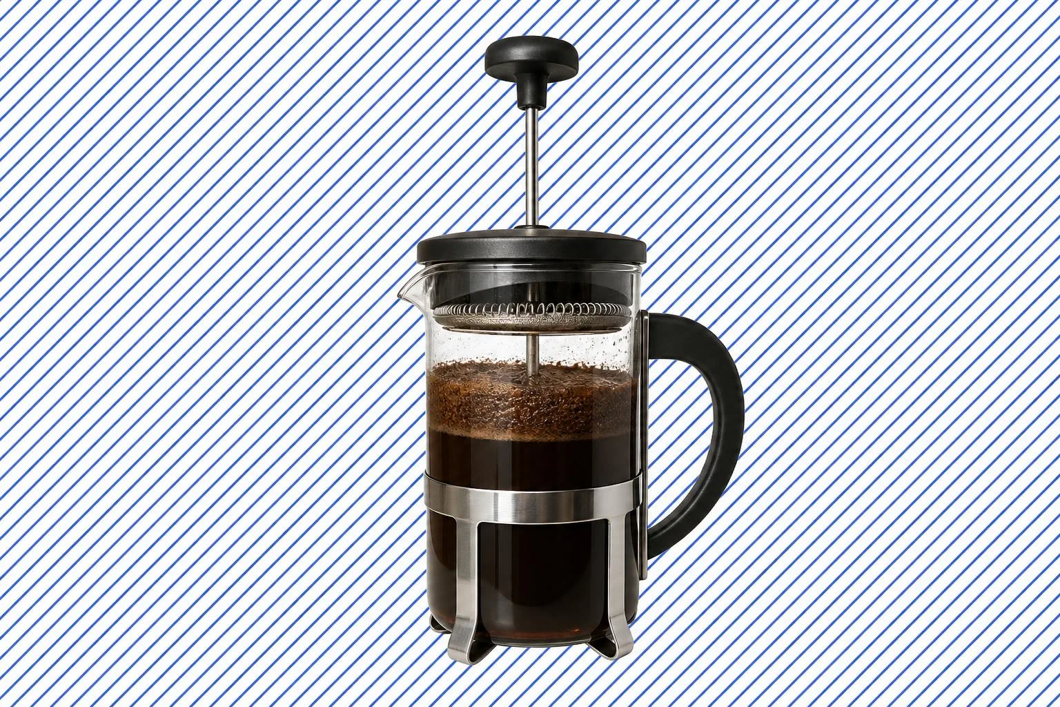 A glass French press with the plunger raised and a floating crust of coffee grounds, set against a flat stylised patterned field.